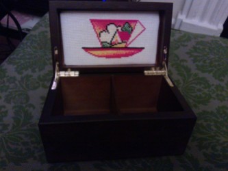 Embroidery padded and mounted in a Twinings tea caddy